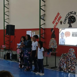 Como exemplo de uma das atividades realizadas na rede estadual de ensino, a imagem registra um momento de apresentações promovida com alunos da EEF Juscelino Kubitschek de Oliveira na última sexta-feira (14), onde todas as turmas realizaram exposições temáticas, destacando também a contribuição de personalidades negras na sociedade. O dia ainda contou com o almoço temático com o prato feijoada. Foto: Divulgação